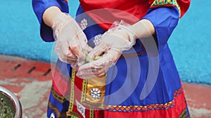 A Zhuang woman is making Chinese Guangxi Zhuang specialties, wormwood cake