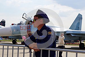 ZHUKOVSKY, RUSSIA, JUL. 2015: Aerospace aircraft exhibition MAKS 2015. Aircraft pilot in navy uniform and brown sun glasses at jet