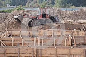 Zhytomyr, Ukraine - October 5, 2020: Wheel loader machine unloading soil during earthmoving works at construction site