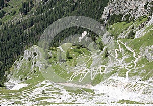 Zig zag footpath descending the steep slope of the Dolomite alps in Italy in summer