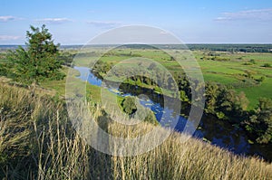 Zigzag river flows between summer valleys