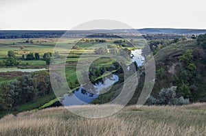 Zigzag river flows between summer valleys