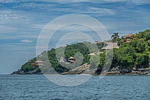 Villas on ocean shoreline cliffs, Zihuatanejo, Mexico photo