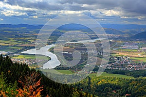 Zilina town in autumn from Mala Fatra mountain. View of the evening city from the mountains in Slovakia, dark grey storm clouds. M