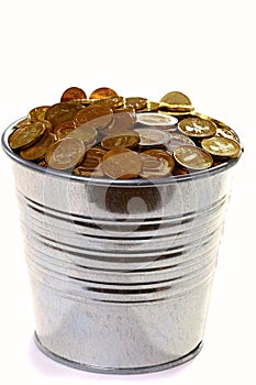 Zinc bucket of gold coins on a white background.