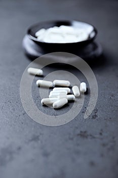 Zinc capsules on dark stone background. Soft focus