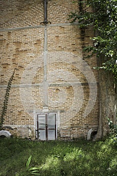 Zinc gate with old bricks wall and grass field