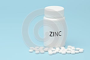ZINC in white bottle packaging with scattered pills. Nutritional supplement. Treatments for COVID-19. isolated on blue background