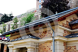 zink gutter. building elevation closeup. brick house facade with gray zink sheet roof