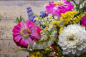 Zinnia flowers and other flowers in a beautiful bouquet on old grunge wooden background ErÃ­geron