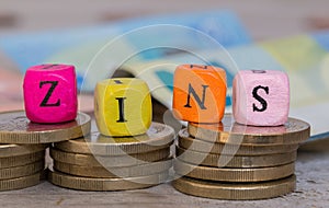 Zins in german Interest alphabet cube on coins concept
