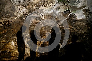 Zinzulusa Caves, near Castro on the Salento Peninsula in Puglia, Italy. Shadows of four people can be seen against the stone walls