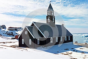 Zion church in Ilulissat Greenland with sunny snowy landscape