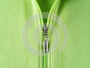 Zip fastener of light green sweatshirt hoodie close-up. Fashionable summer cotton jacket with zipper fastening. Trendy clothes in