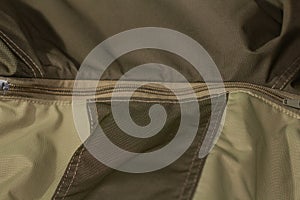 Zipper on beige workwear protective clothing in close-up.