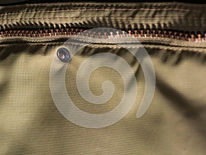 Zipper on beige workwear protective clothing in close-up.