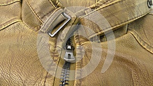 Zipper on the brown leather jacket unfolds.