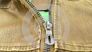 The zipper opens on the brown leather jacket.