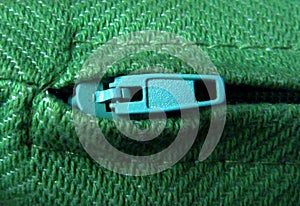 Zipper puller macro with green wool fabric and fine stitching