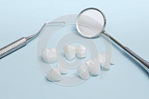 Dental tools and Zircon dentures on a blue background - Ceramic veneers - lumineers photo