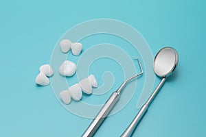 Dental tools and Zircon dentures on a blue background - Ceramic veneers - lumineers photo