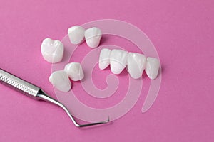 Dental tool and Zircon dentures on a pink background - Ceramic veneers - lumineers photo