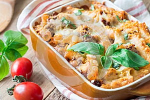 Ziti bolognese in baking dish. Pasta casserole with minced meat, tomato sauce and cheese, horizontal