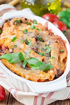 Ziti bolognese in baking dish. Pasta casserole with minced meat, tomato sauce and cheese, vertical