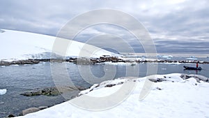 Zodiac approaching snow covered slopes in Antarctica