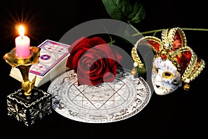 Zodiac horoscope, bright candle, red rose, Queen of flowers, cards for predictions, carnival jester mask, symbol of transformation photo