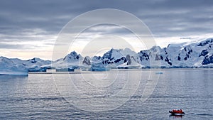 Zodiac among icebergs in a bay in Antarctica