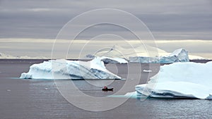 Zodiac among icebergs in a bay in Antarctica