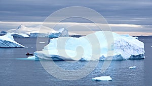 Zodiac among icebergs in a bay in Antarctica