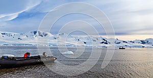 Zodiacs boats in the snow fjord of Neco bay