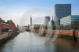 Zollkanal canal at Speicherstadt and Hamburg skyline with St. Catherine Church - Hamburg, Germany