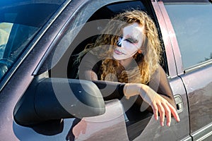 Zombie girl with black eyes and a bloody mouth on Halloween