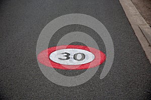 Zone 30 text paint city road car sign to limit town center vehicle speed to 30km per hour