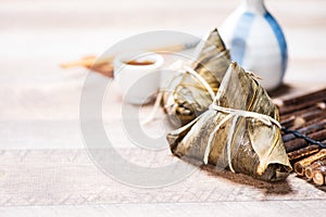 Zongzirice dumpling with a cup of tea on a wood table, Dragon Boat Festival, Asian traditional food