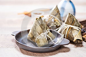 Zongzirice dumpling with a cup of tea on a wood table, Dragon Boat Festival, Asian traditional food