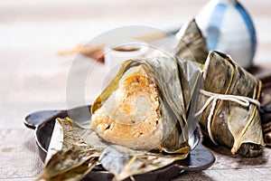 Zongzirice dumpling with a cup of tea on a wood table, Dragon Boat Festival, Asian traditional food