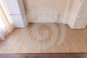 Zoning floor in interior, ceramic kitchen tiles bordered with laminate flooring in the living room