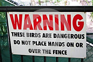 Zoo warning sign on fence for dangerous large birds.