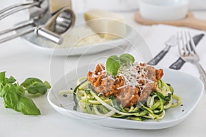 Zoodles bolognese: zucchini noodles with meat or vegan soy meat sauce and parmesan