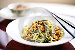 zoodles with diced tofu and soy sauce in a dish