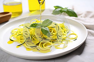 zoodles drizzled with olive oil on a white plate