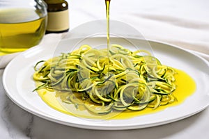 zoodles drizzled with olive oil on a white plate