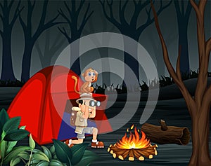 Zookeeper boy and his monkey camping in a dark forest