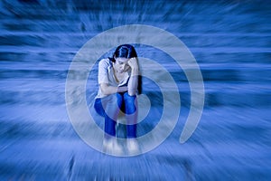 Zoom blur edited portrait of young sad and depressed woman or teen girl sitting lonely at street staircase looking desperate and s