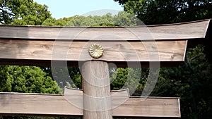 zoom in close up of a large torii gate with ite imperial seal at meiji shrine in tokyo