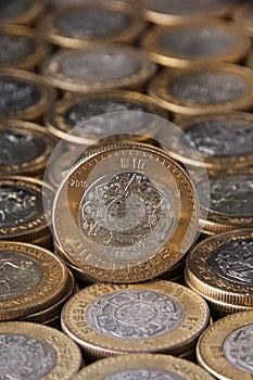 Zoom in moneda de diez pesos mexicanos sobre mÃÂ¡s monedas alineadas y apiladas, Toma vertical photo